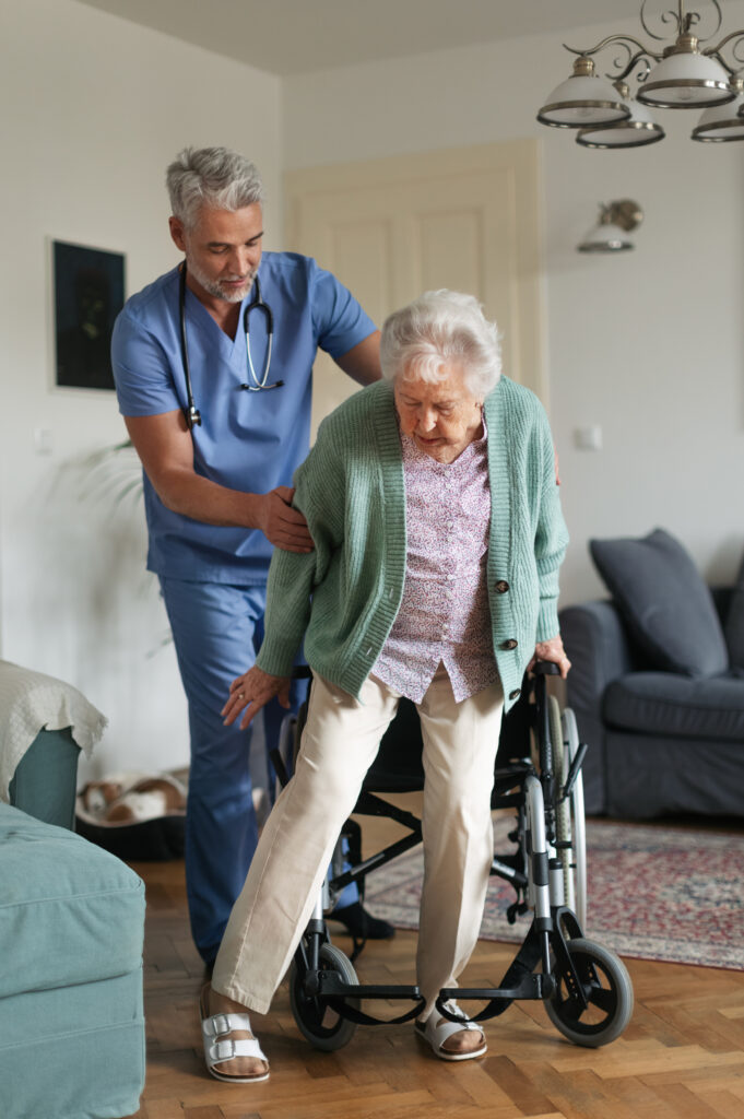 Caregiver helping senior woman to stand